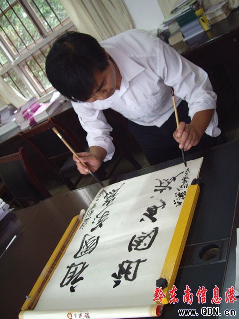 黎平老師有“絕活” 兩手執(zhí)筆能同時(shí)書寫(圖)