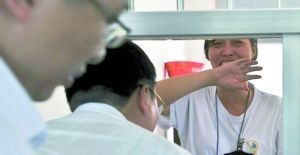 唐慧(右一)在勞教所見到自己的辯護律師禁不住潸然淚下。圖片來源:重慶晨報